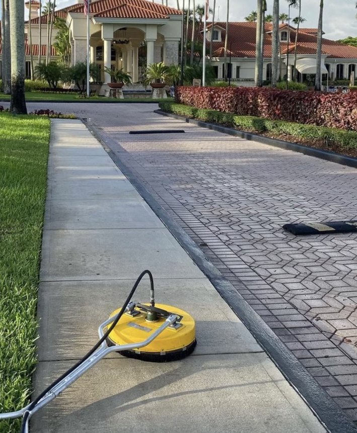 GWS surface cleaner mid-job on a walkway, washed strip clearly visible against the dirty concrete