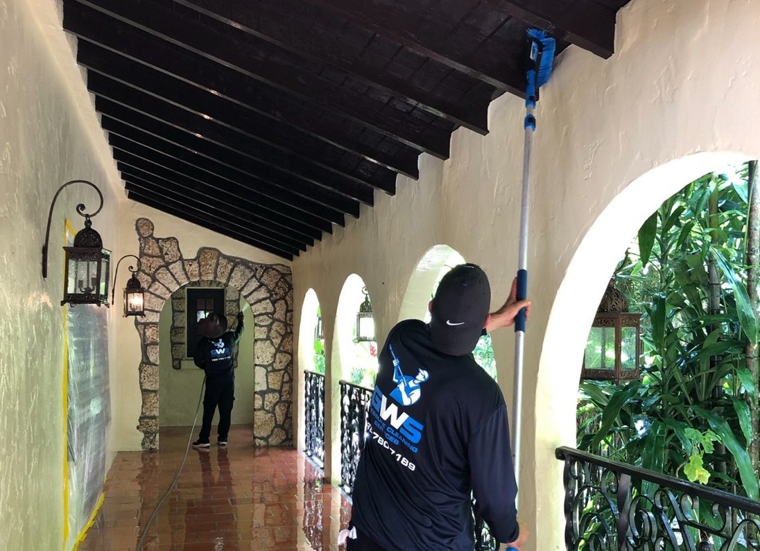 A GWS painter rolling a wall with an extension pole at a Miami home