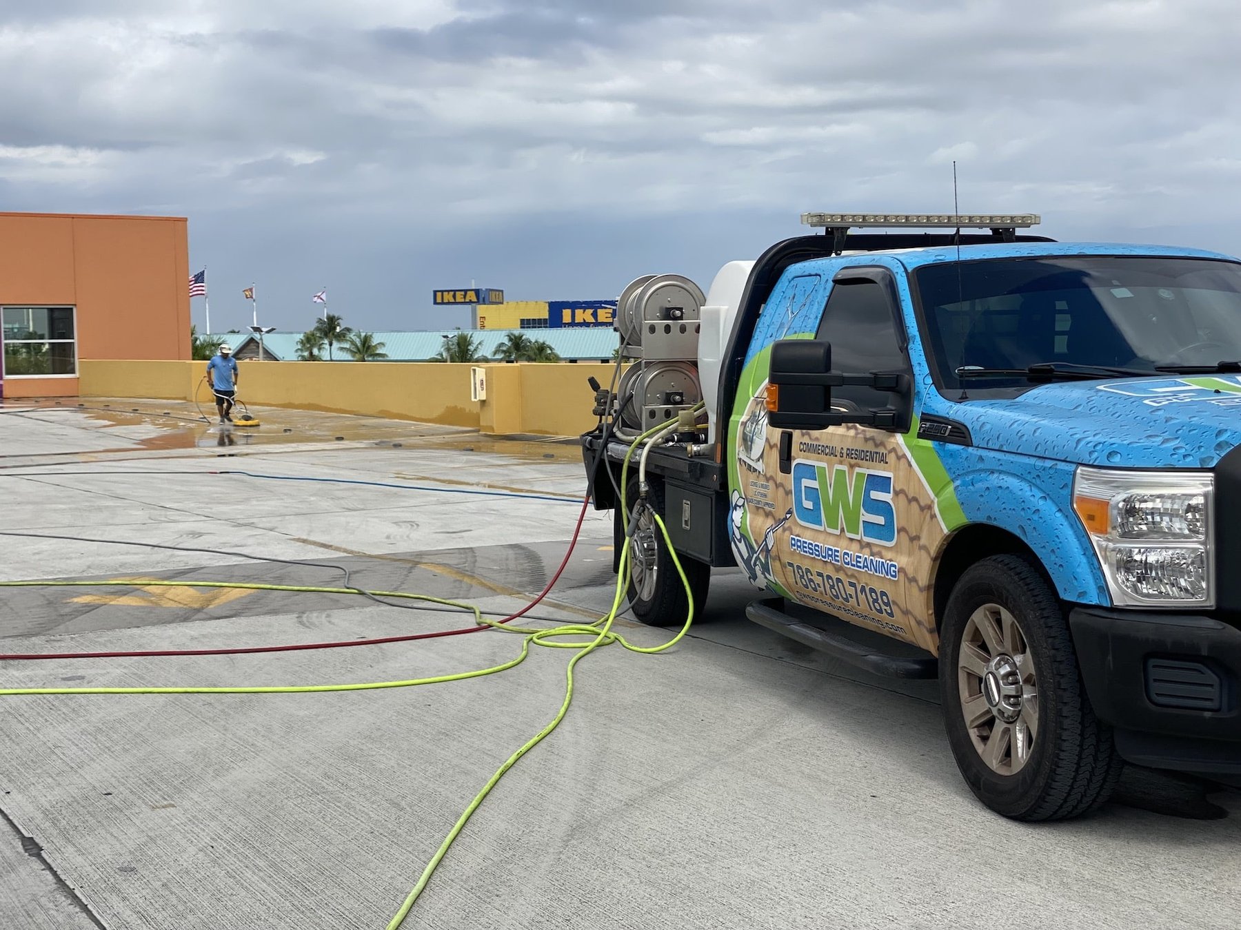 The GWS Pressure Cleaning truck and rig set up on a parking deck in Miami, hoses run out and crew working